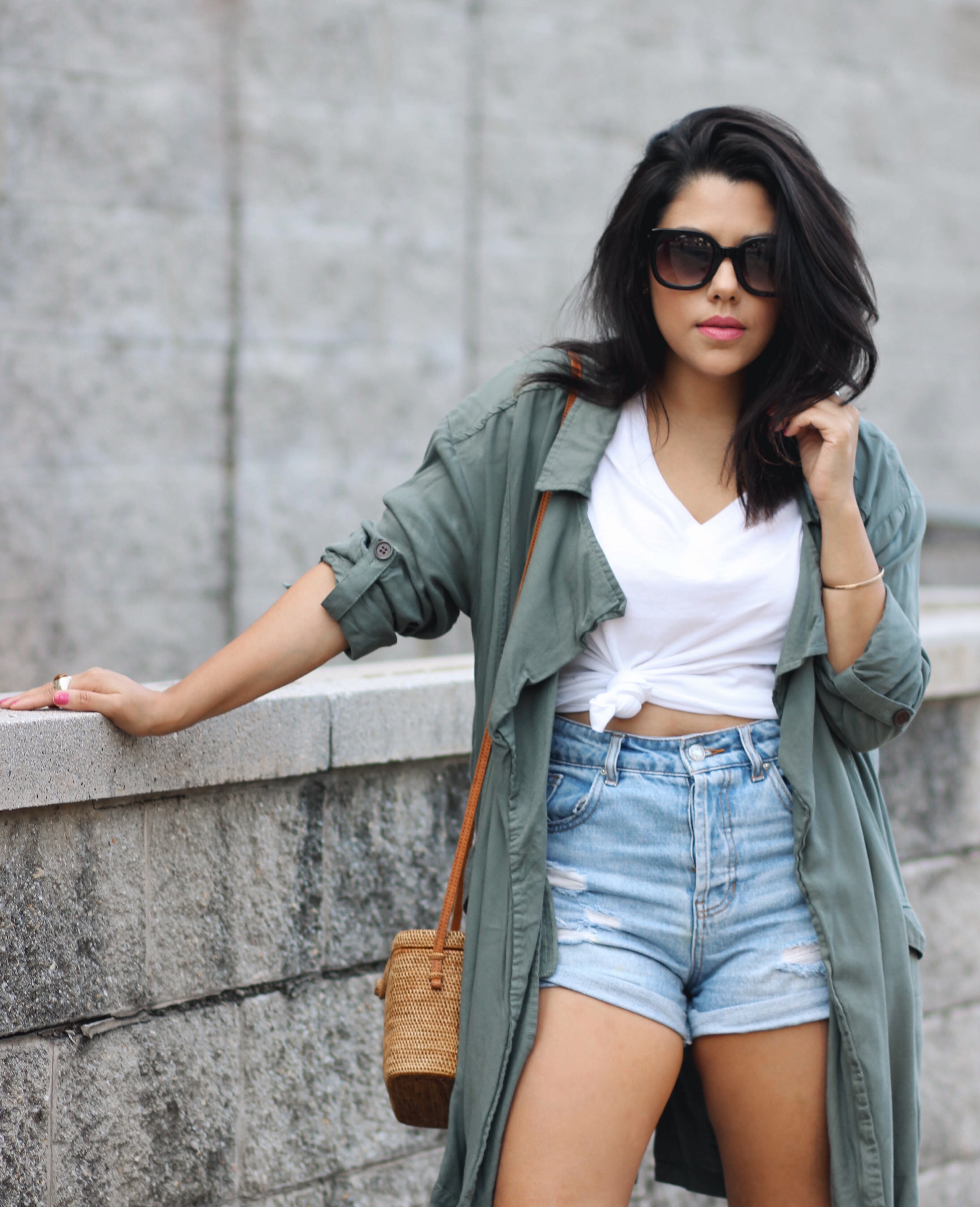 lifestyle blogger naty michele wearing a knotted tee with denim shorts and a trench coat