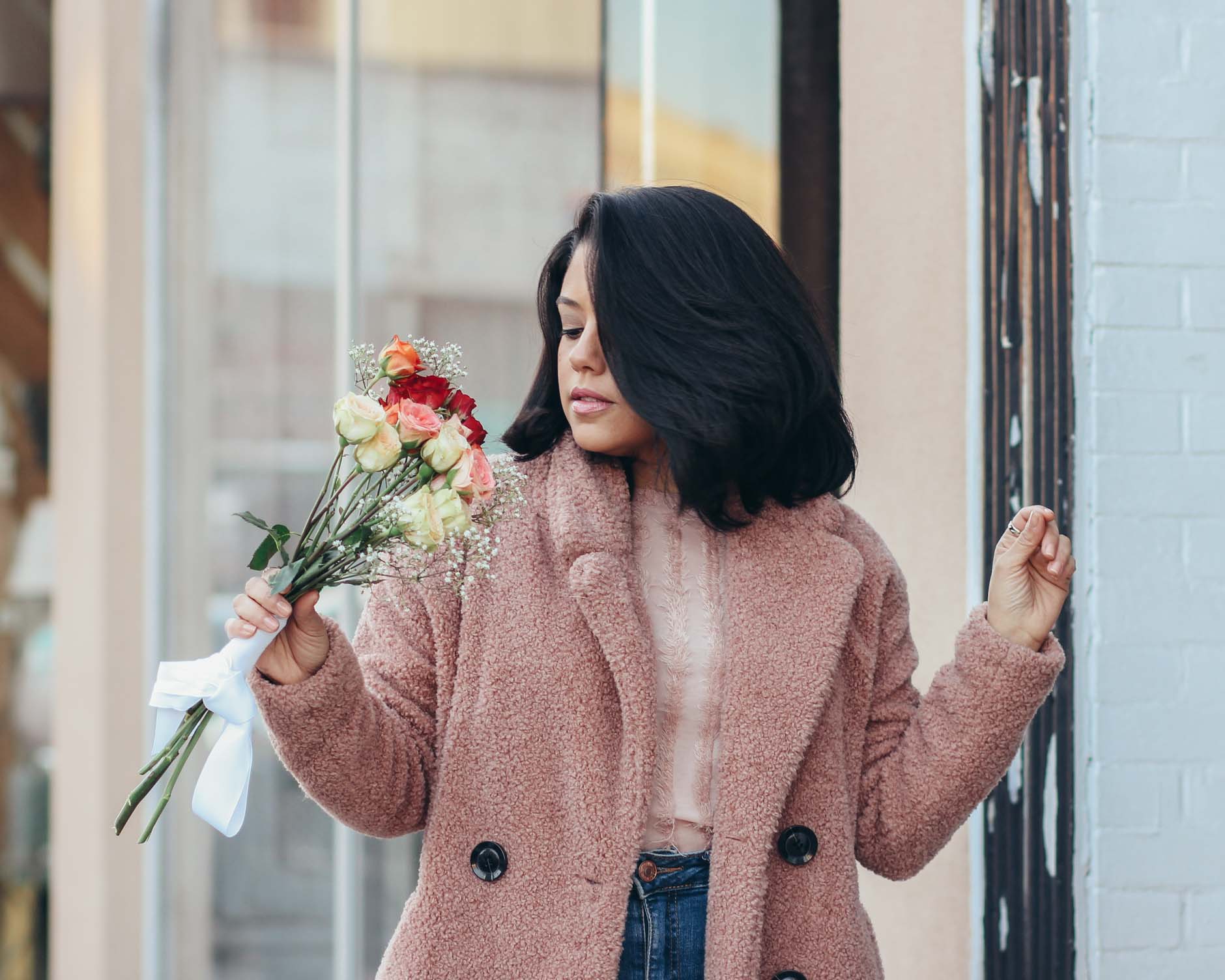 lifestyle blogger naty michele wearing a teddy coat and holding roses 