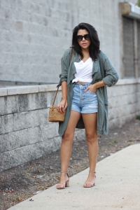 lifestyle blogger naty michele wearing a knotted tee with denim shorts and a trench coat and basket bag