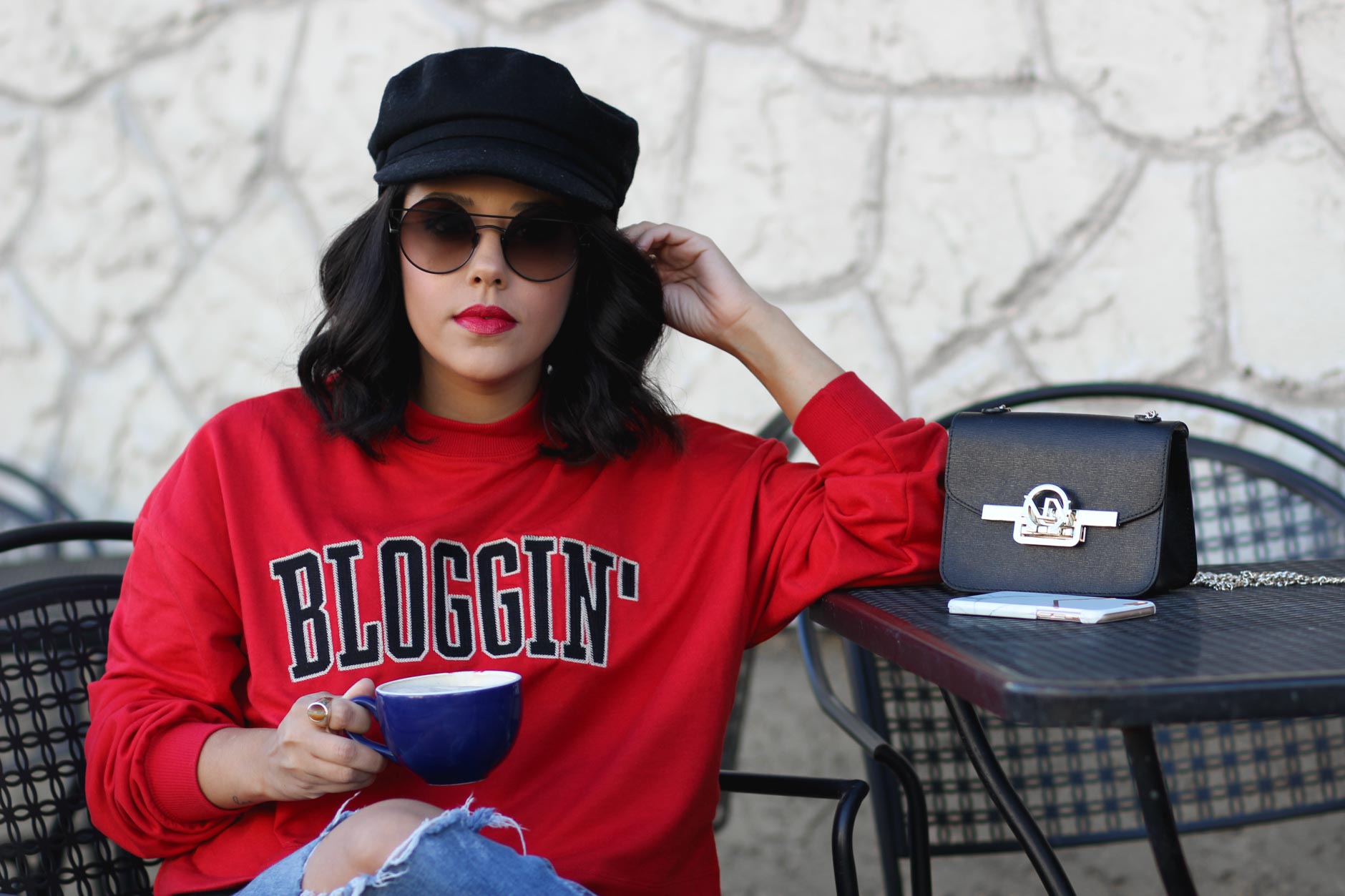 lifestyle blogger naty michele wearing a blogging sweatshirt holding coffee