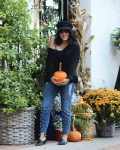 lifestyle blogger naty michele wearing pearl jeans holding a pumpkin