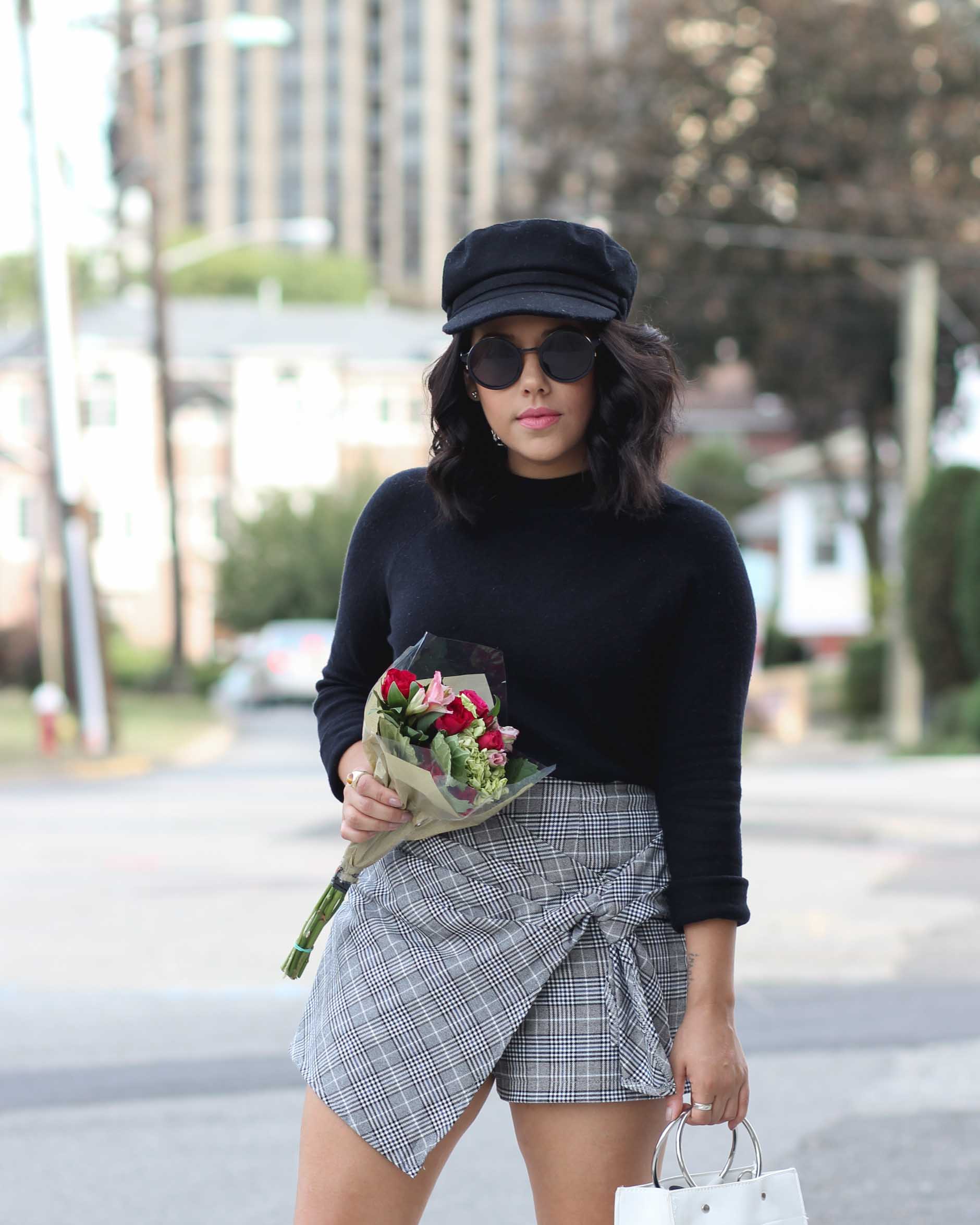 lifestyle blogger naty michele wearing a plaid skort and sock boots
