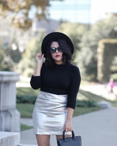 lifestyle blogger naty michele wearing a black sweater and silver skirt and wide brim hat