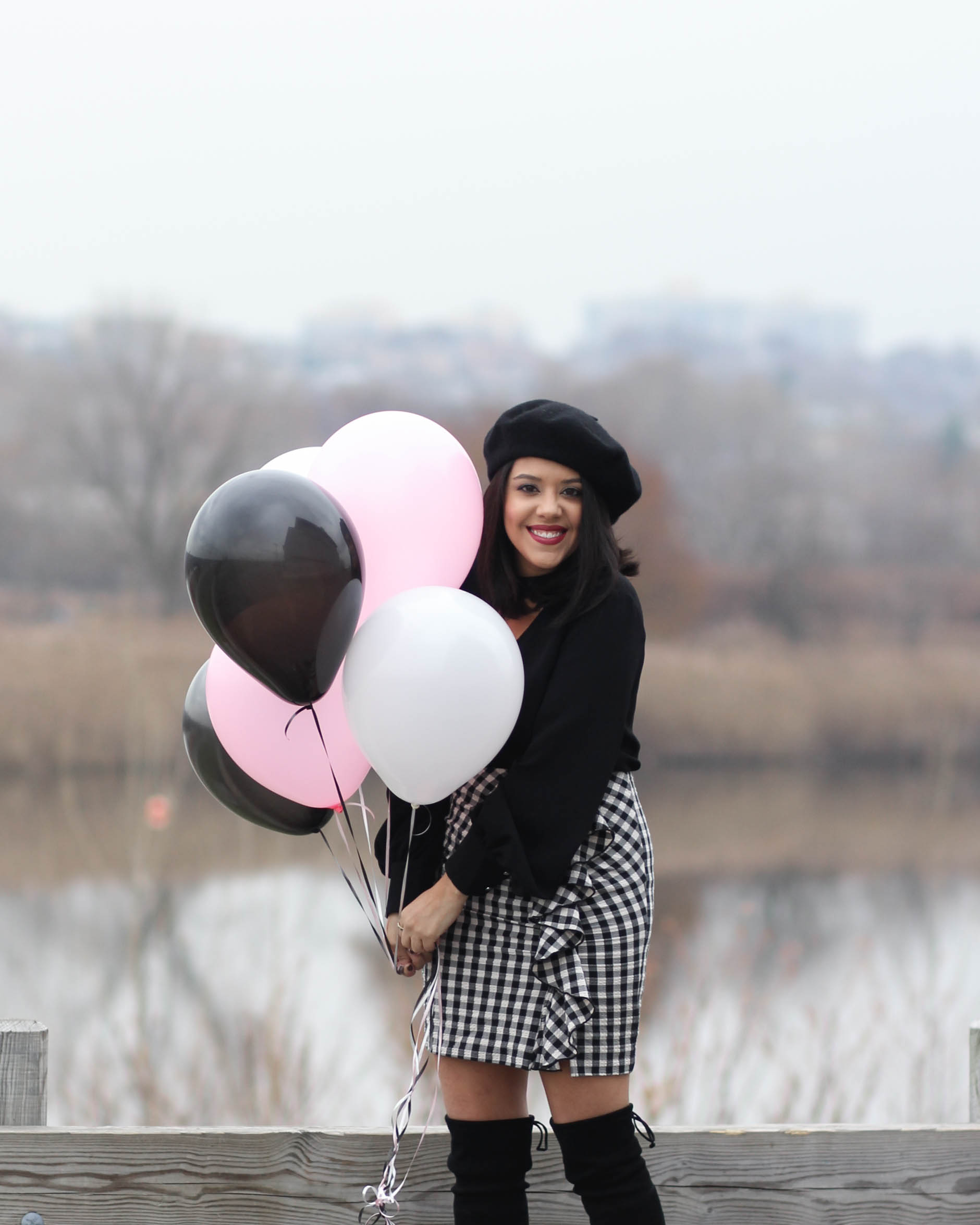 lifestyle blogger naty michele wearing beret and holding balloons