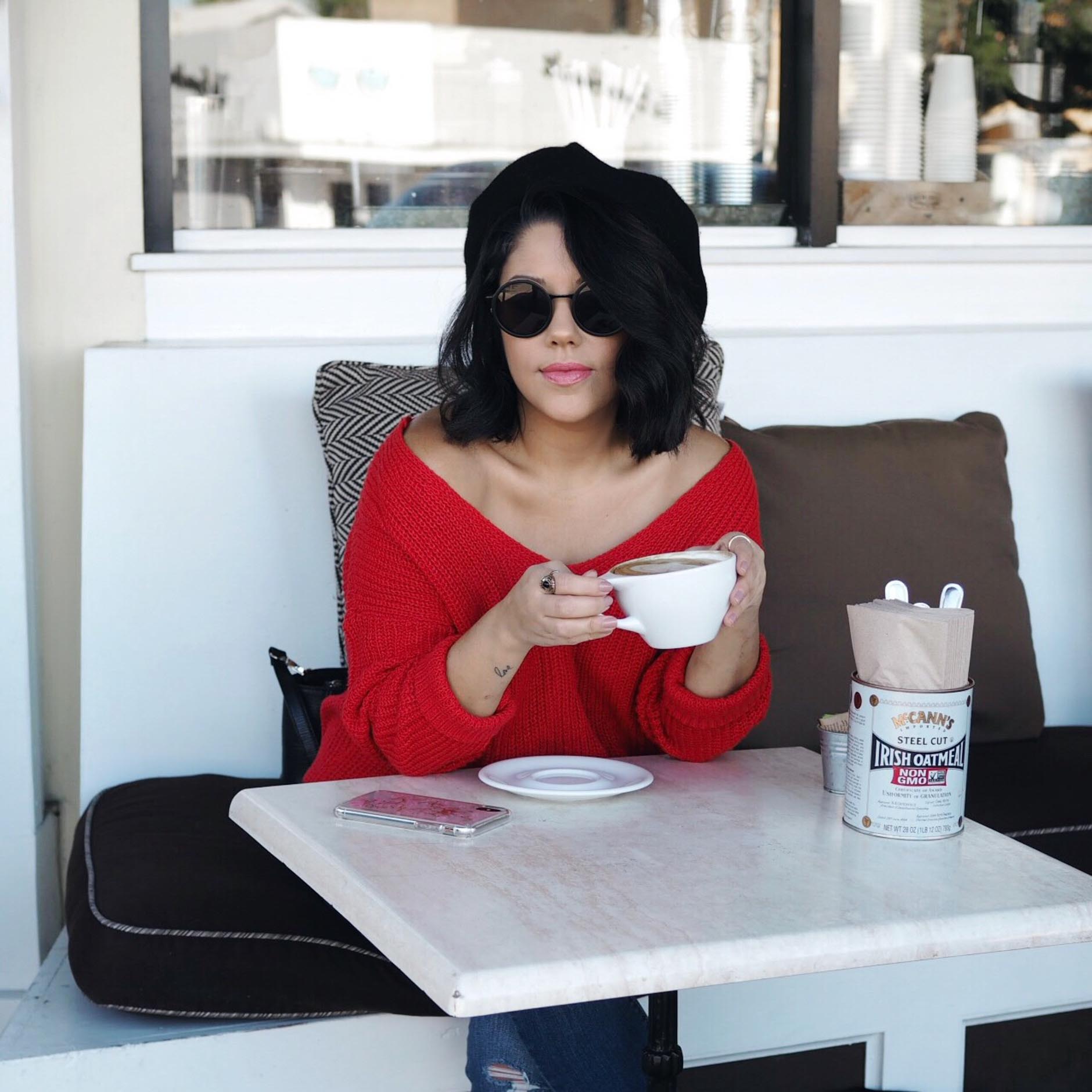 naty michele wearing off the shoulder sweater drinking coffee