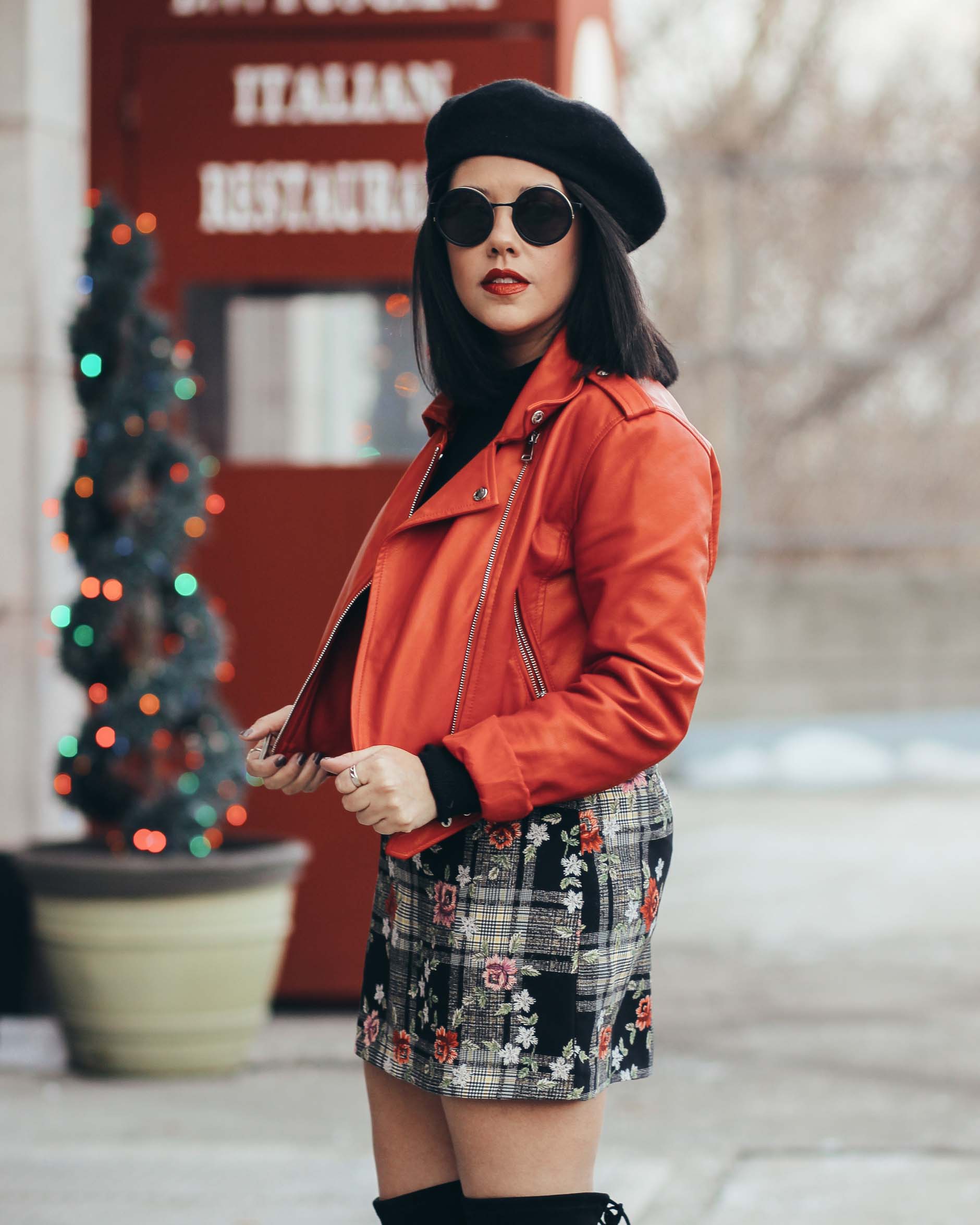 naty michele wearing a red moto jacket with floral skirt