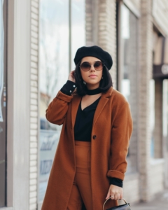 close up of lifestyle blogger naty michele wearing a camel coat with a black top and beret