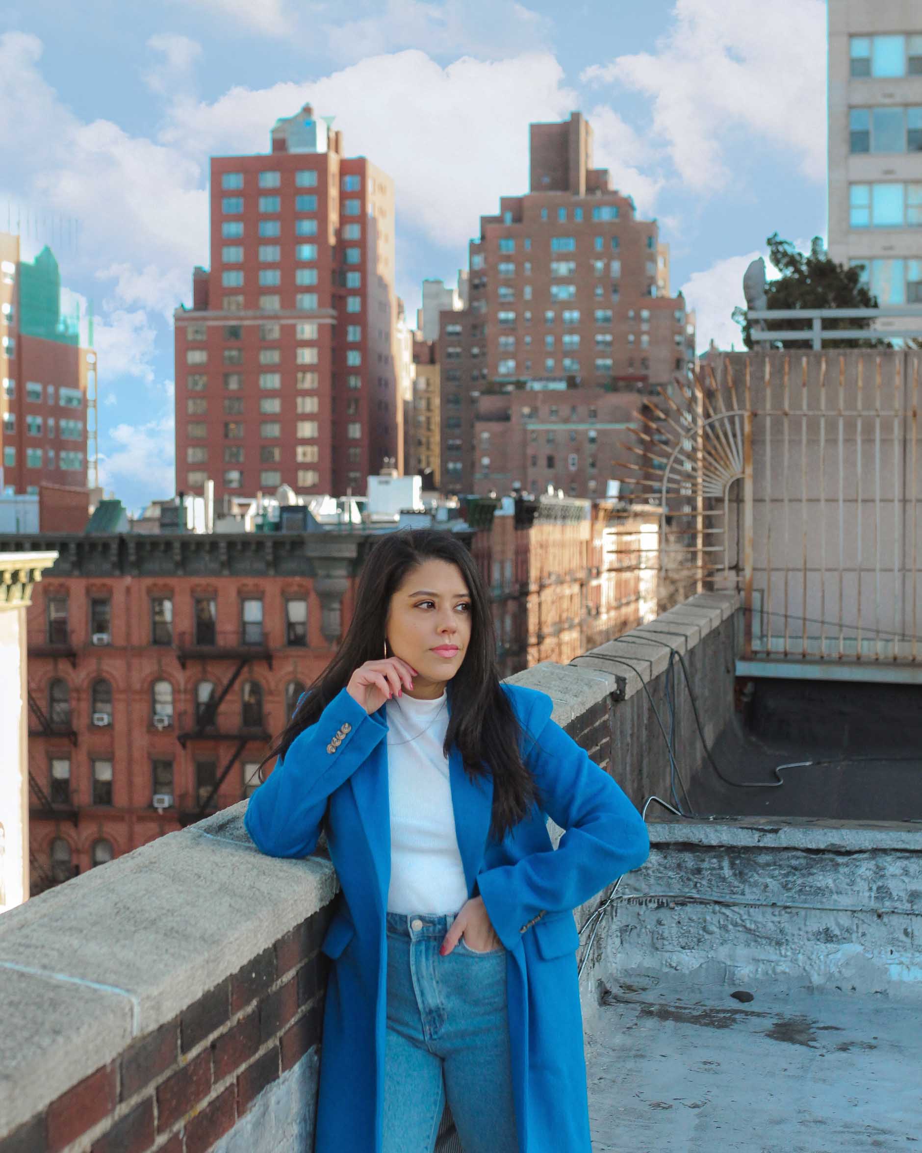 naty michele in a blue coat on a new york city rooftop